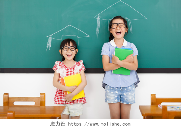 教室里两个快乐的小女孩即将毕业快乐的小女孩，与毕业概念在教室里